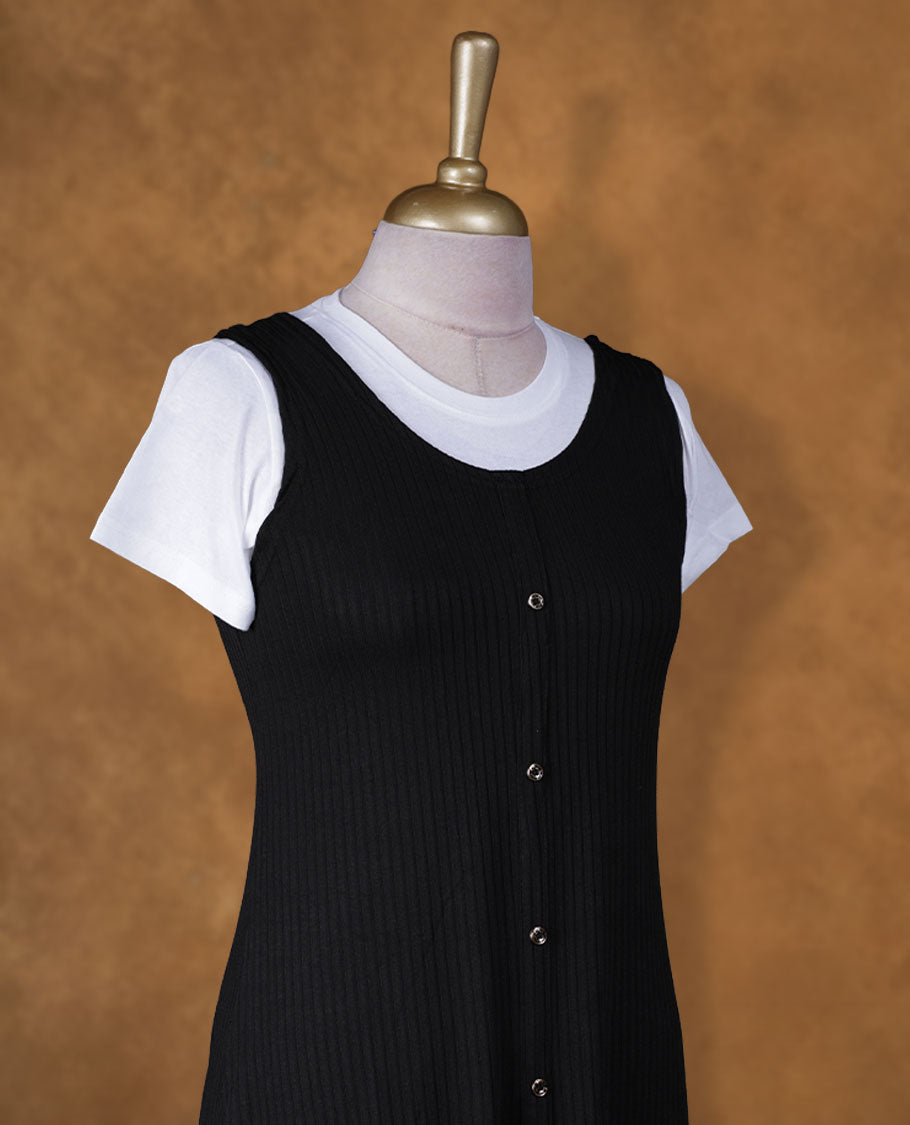 Black sleeveless A-line midi dress with front button detailing, layered over a white crew-neck short-sleeve inner tee
