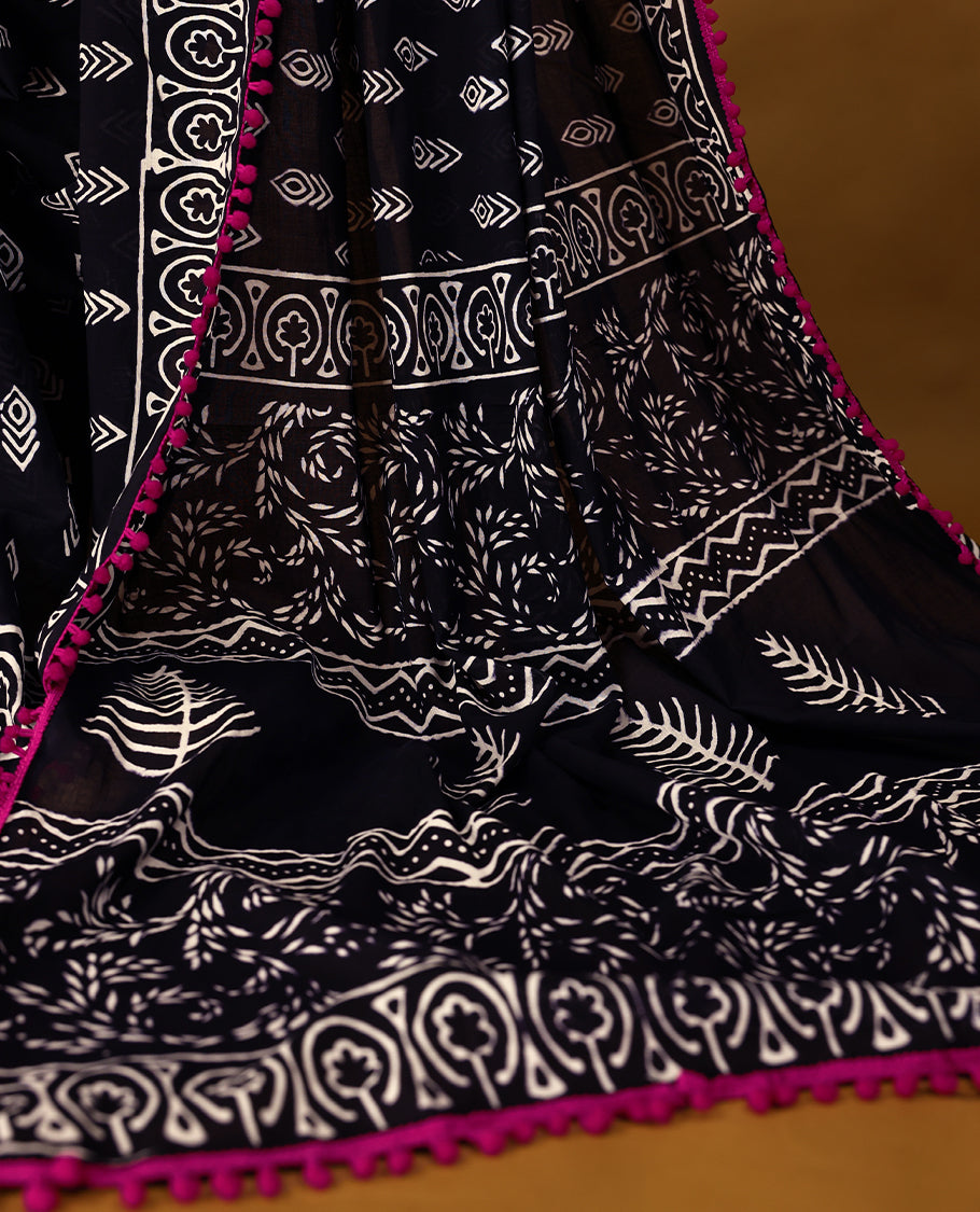 Black cotton saree features intricate white handblock prints, a beautifully detailed border with Pink piping and Self Coloured Blouse