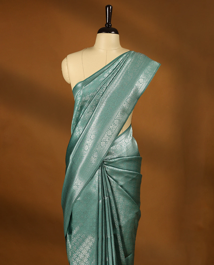 Pastel Aqua coloured semi silk saree featuring a Silver coloured Zari Diamond design on the body, paired with a Self coloured border and matching blouse.