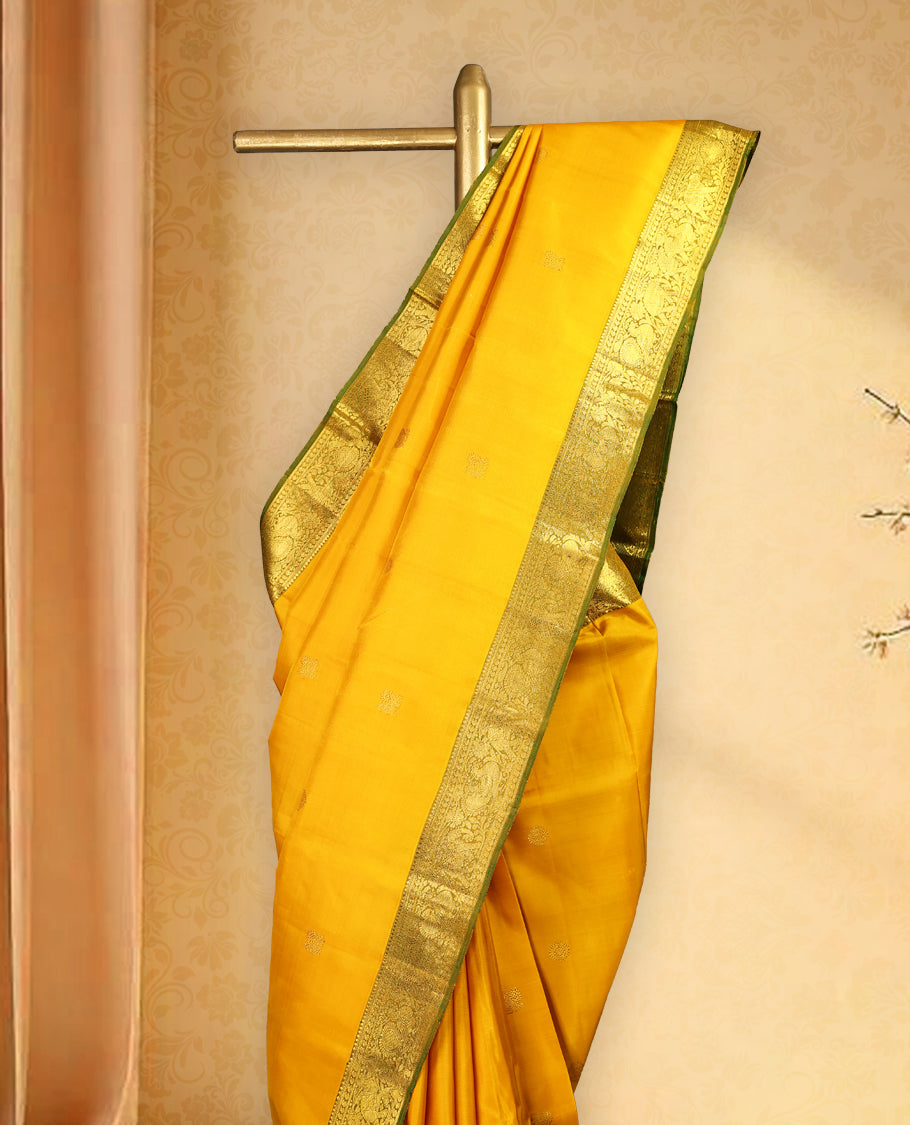 Mustard colour pure Kancheepuram saree with gold zari Mayoora chackra motifs on the body traditional contrast border with elephant and annam motifs grand pallu paired with matching blouse