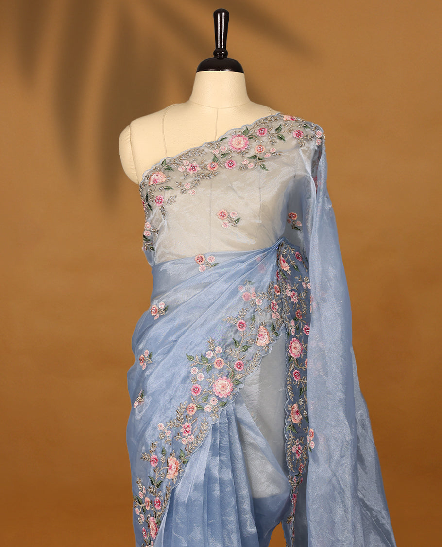 Powder Blue Organza Tissue Silk Saree is beautifully adorned with intricate pink floral embroidery Border and a matching blouse.