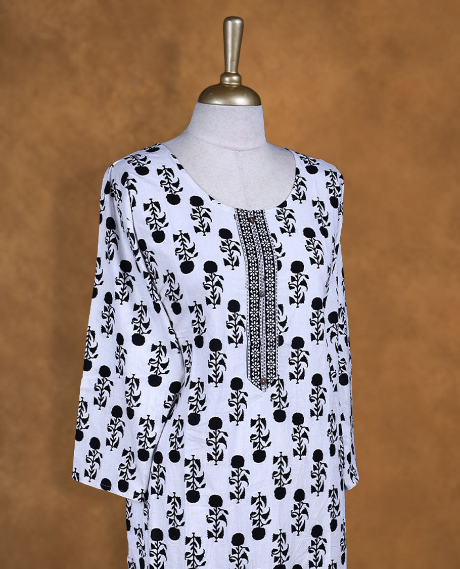 White and black colour kurti with black floral prints, knee length design, styled with a round neckline and a sleeve .