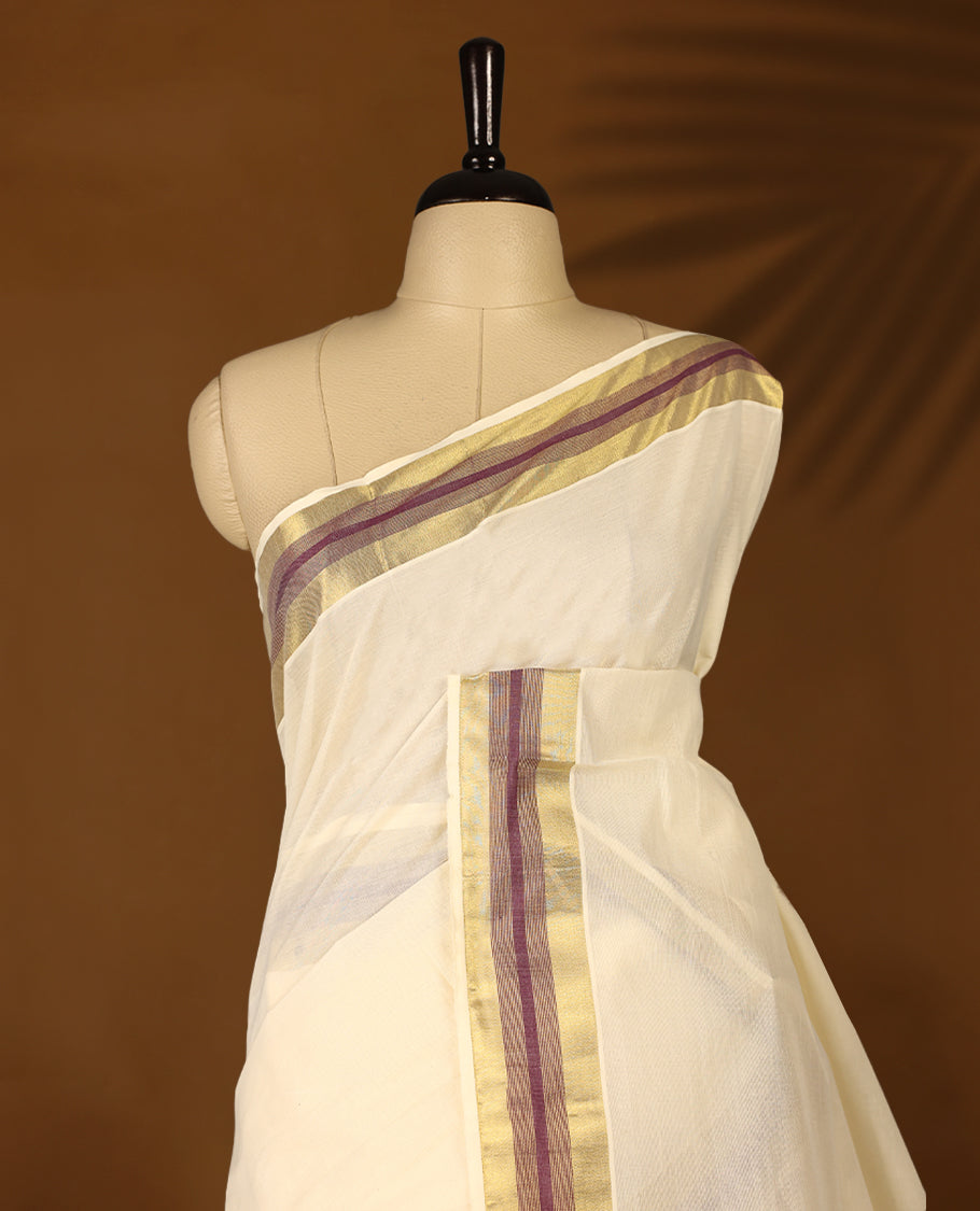 Elegant off white colour cotton Kerala saree featuring Plain body, Grape colour & golden zari kasavu border offering a classic and graceful look, paired with a matching blouse.