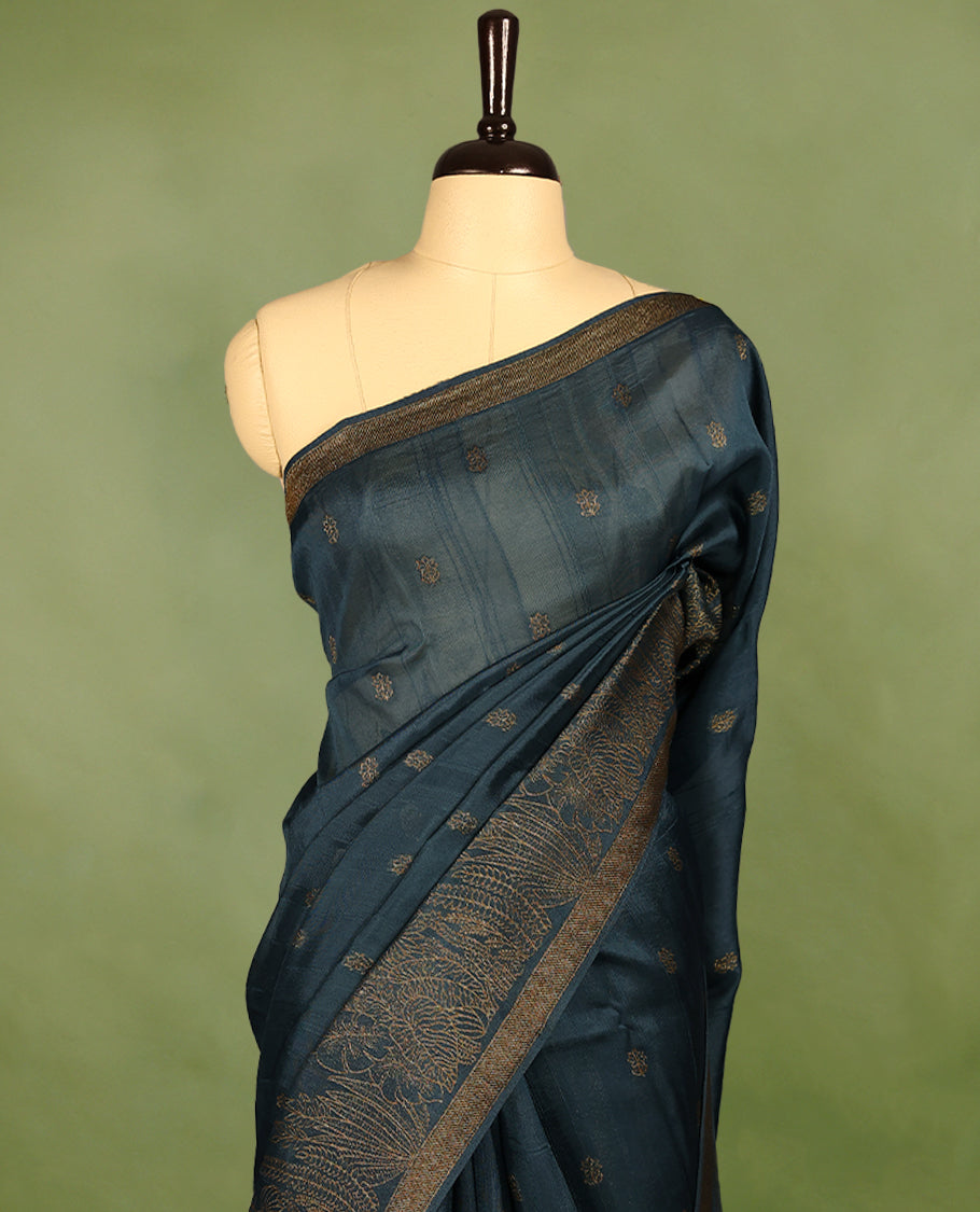 German blue semi-Banaras tussar georgette saree adorned with antique zari floral motifs on the body, beautifully highlighted with a pencil art garden-inspired border, paired with a matching blouse.