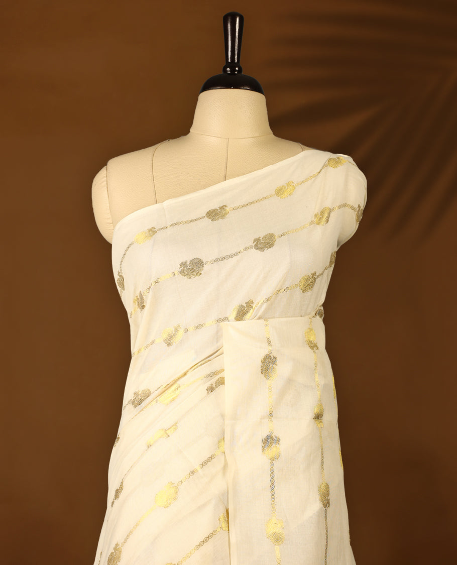 Elegant off white colour cotton Kerala saree featuring a gold Zari stripes with peacock motifs on body, with purple colour tassels offering a classic and graceful look, paired with a matching blouse.