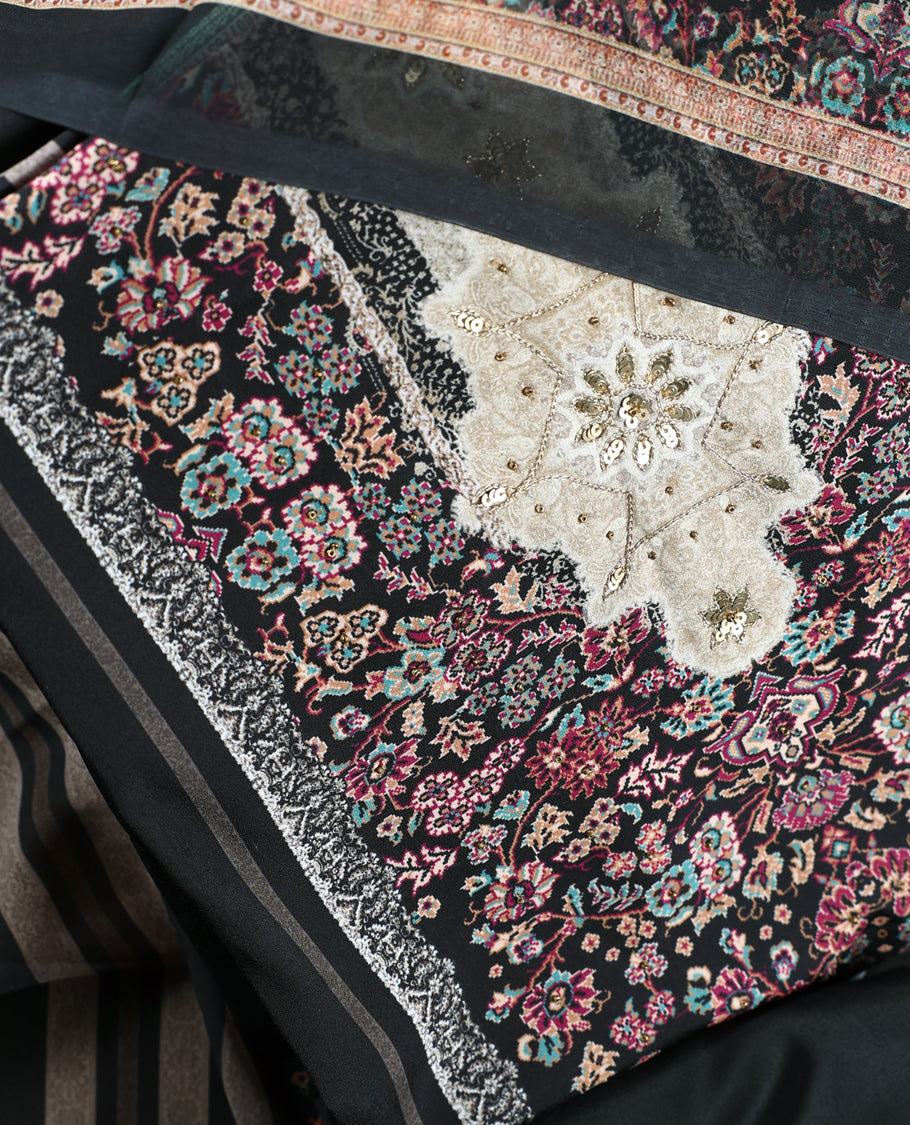 Black colour churidhar set featuring floral prints in pink, teal & beige, paired with plain black bottom and matching dupatta adorned with elegant embroidery.