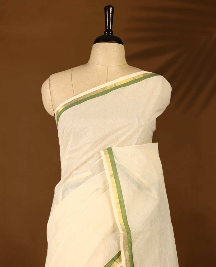 Elegant off white colour cotton Kerala saree featuring a plain body and traditional golden zari border with a hint of Olive Green, offering a classic and graceful look, paired with a matching blouse.