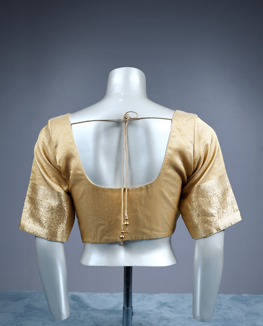 Golden tissue padded readymade blouse with a subtle sheen, highlighted by elbow length zari woven sleeves and a square neckline an elegant versatile piece ideal for silk and festive sarees.