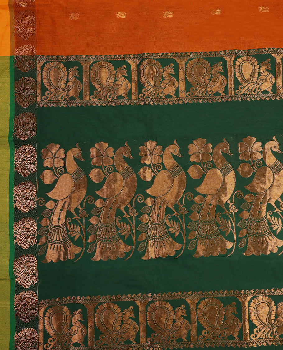 Rust Orange colour mixed Kalyani cotton saree featuring Copper zari Peacock motifs throughout the body, paired with Bottle Green colour traditional border and pallu, with matching blouse