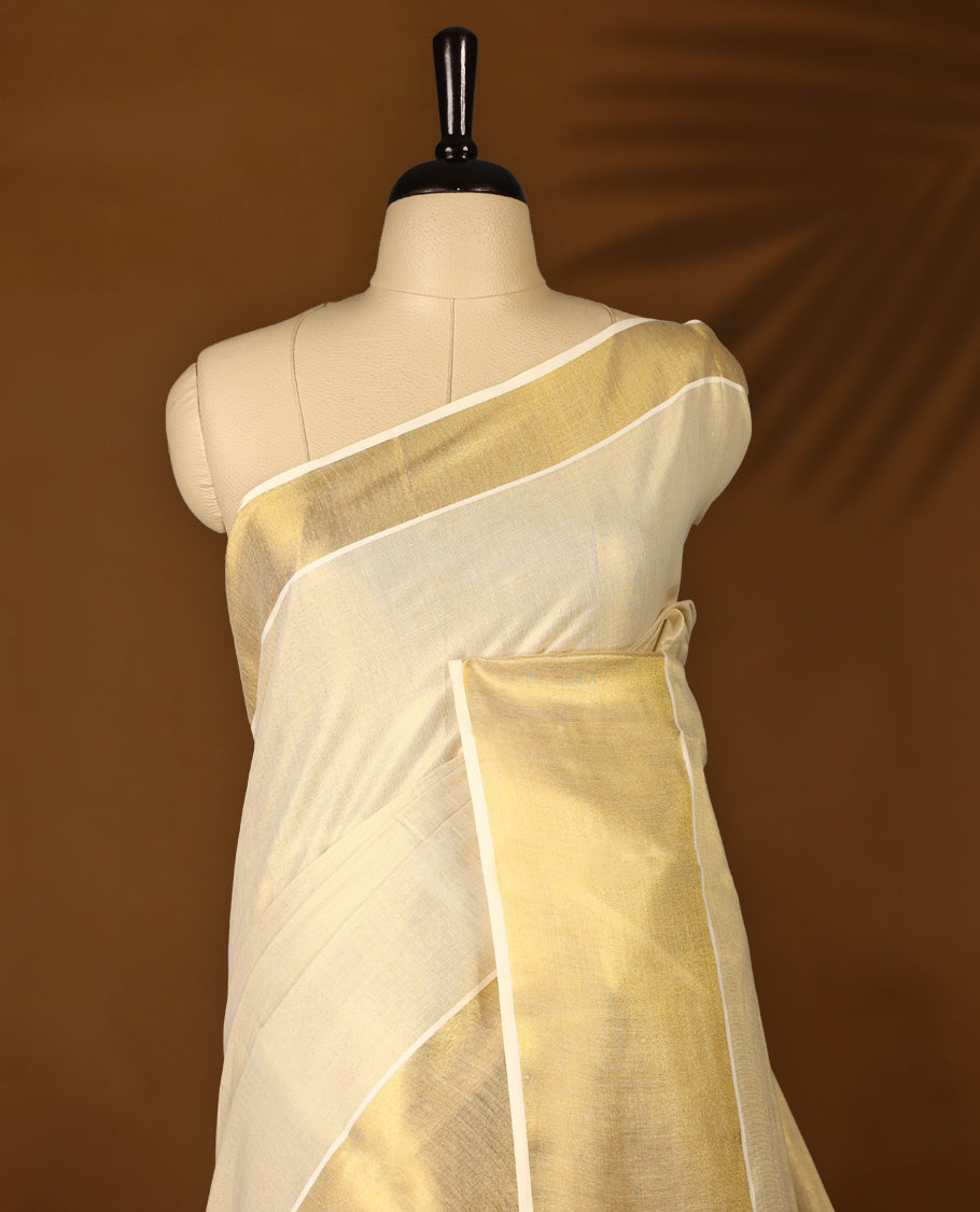 Light Gold colour Tissue Kerala saree featuring Plain body and a beautifully woven muted Gold Kasavu border, Grand Pallu paired with a matching blouse perfect for festive occasions.