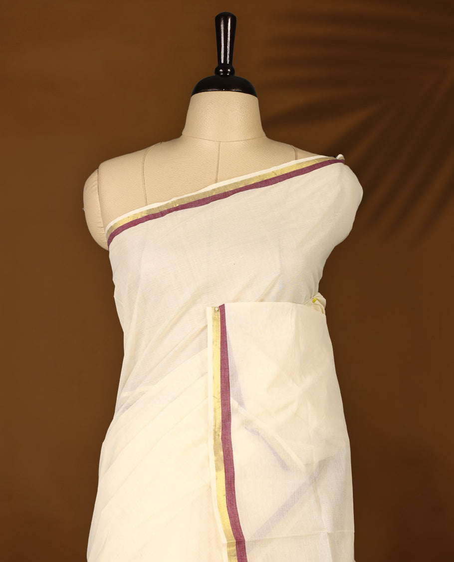 Elegant off white colour cotton Kerala saree featuring a plain body and traditional golden zari border with a hint of maroon, offering a classic and graceful look, paired with a matching blouse.