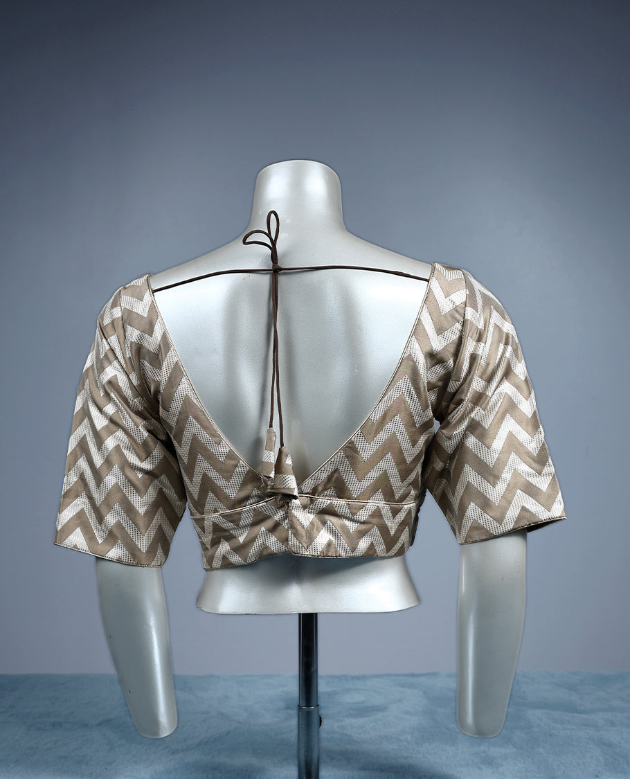 Beige and cream V neck padded readymade blouse featuring a bold chevron pattern with elbow length sleeves, crafted in a glossy fabric for a stylish, contemporary ethnic look.