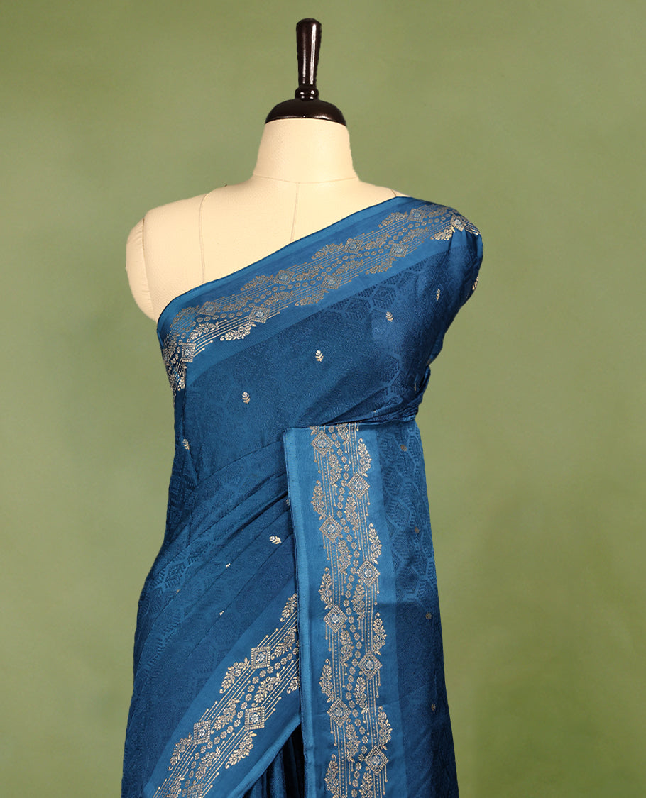 Peacock Blue colour pure Banaras crepe saree showcases elegant Gold & Silver zari Motifs all over the body, a traditional gold & Silver zari border, a rich intricately woven pallu, and comes with a matching blouse.