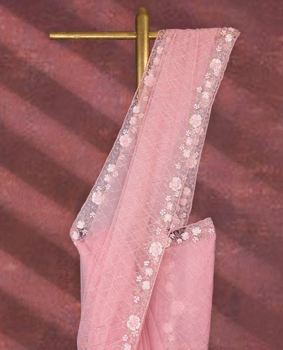 Baby Pink colour net designer saree featuring crisscross cut beads detailing on the body, adorned with beads and sequin worked floral kodi scallop border, paired with a matching worked blouse