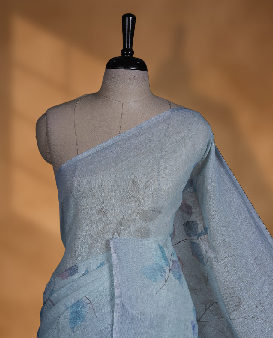 Ice blue colour pure linen saree featuring leaf print pattern across body, silver thin border finished with matching blouse.