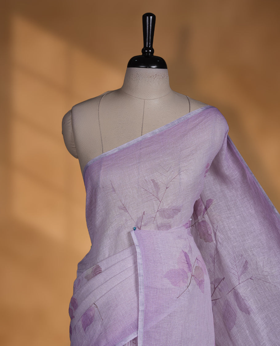 Lavender colour pure linen saree featuring leaf print pattern across body, silver thin border finished with matching blouse.