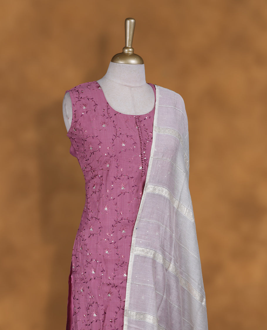 Dusty mauve colour churidar set featuring round neckline, sleeveless pattern, and delicate tonal thread and sequin embroidery on body, paired with a soft white and mauve dip‑dyed striped dupatta.
