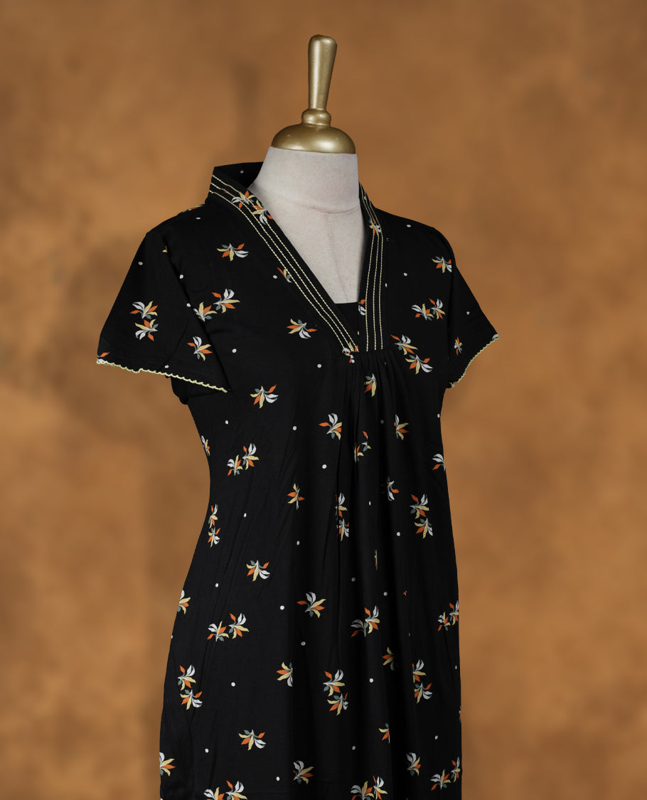 Black colour Nstyle nighty with featuring a floral pattern, a V neckline with yellow theard detailing, Short sleeve, and a full-length
