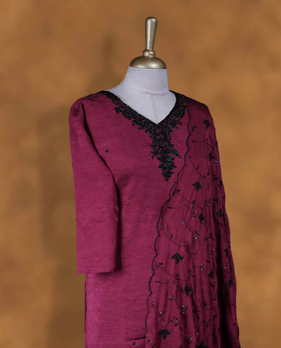 Wine purple colour churidar set featuring V neckline, three‑fourth sleeves, and black bead and thread embellishment along neckline and body, paired with a matching embroidered dupatta.