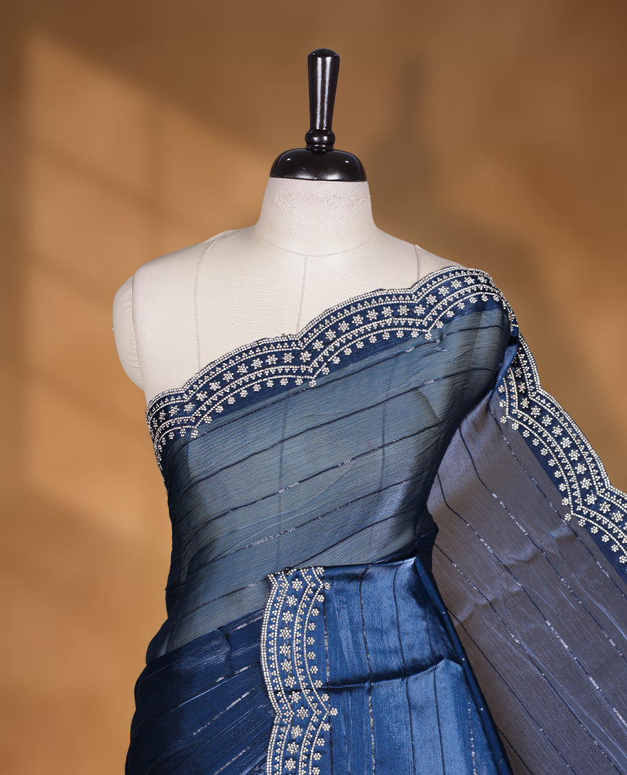 Dark blue colour chiffon designer saree, featuring self colour beats stripes on body, heavy gold stone patttern on border and pallu, Paired with matching blouse.