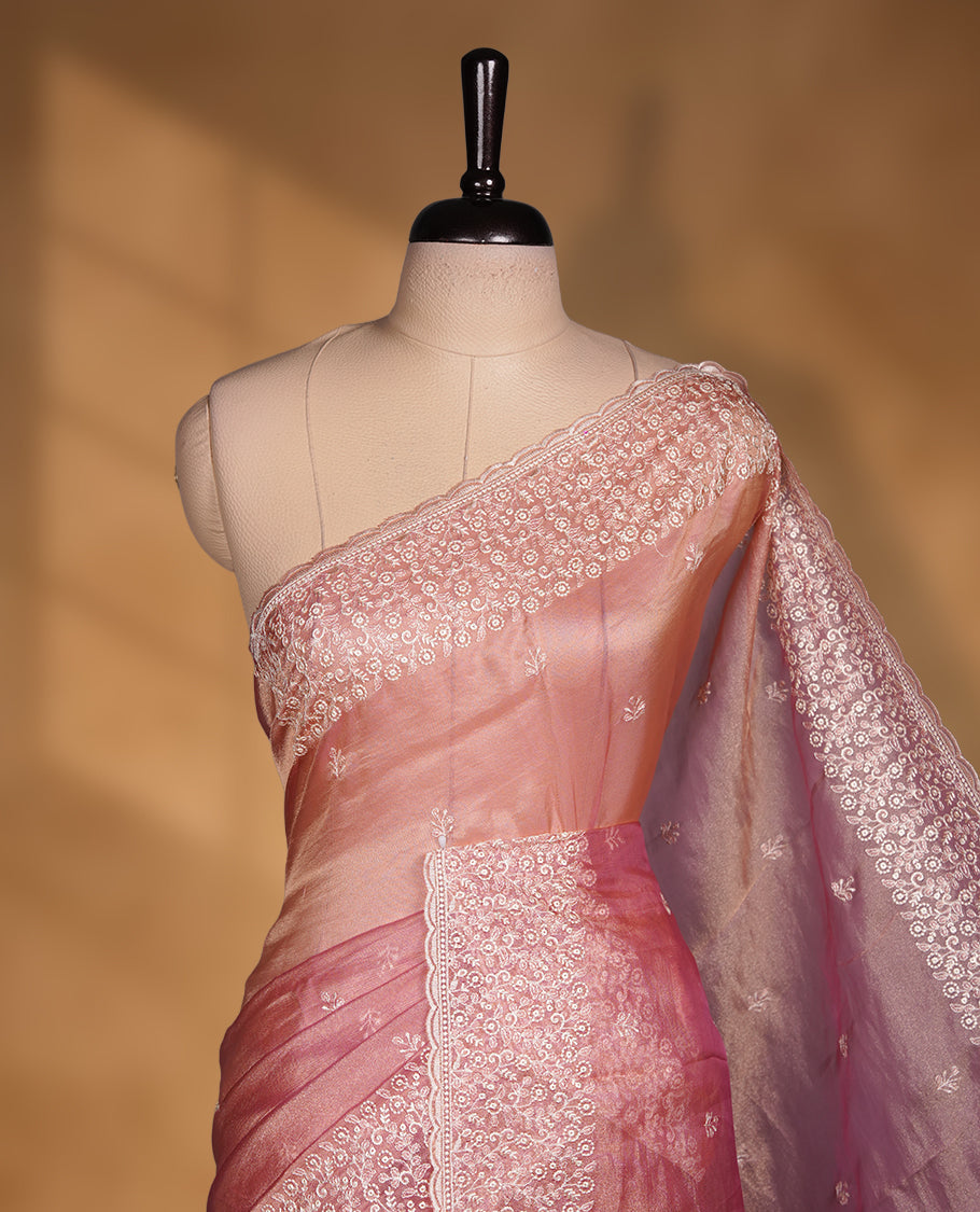 Pastel Pink colour net organza saree featuring white thread embroidery motifs on body and thread detailing on the border and paired matching blouse.