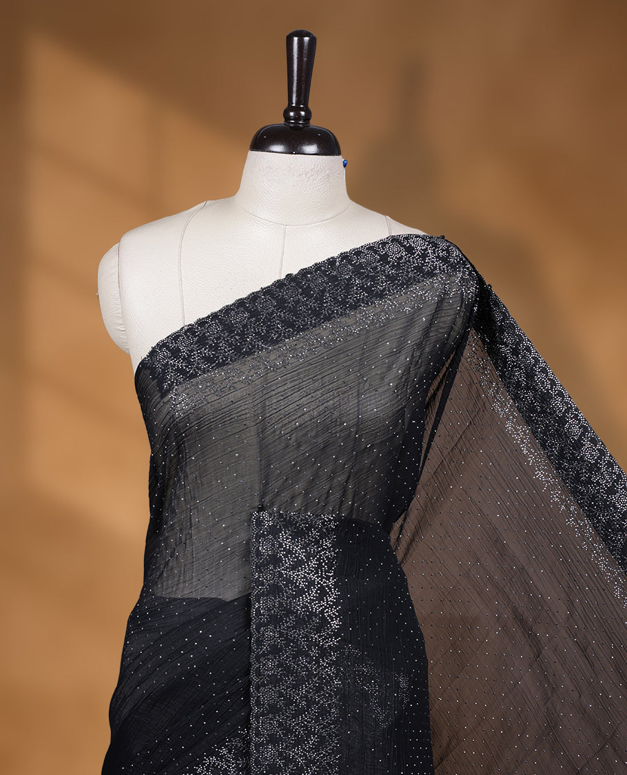 Black colour chiffon designer saree, featuring white stone all over on body, heavy stone patttern on border and pallu, Paired with matching blouse.
