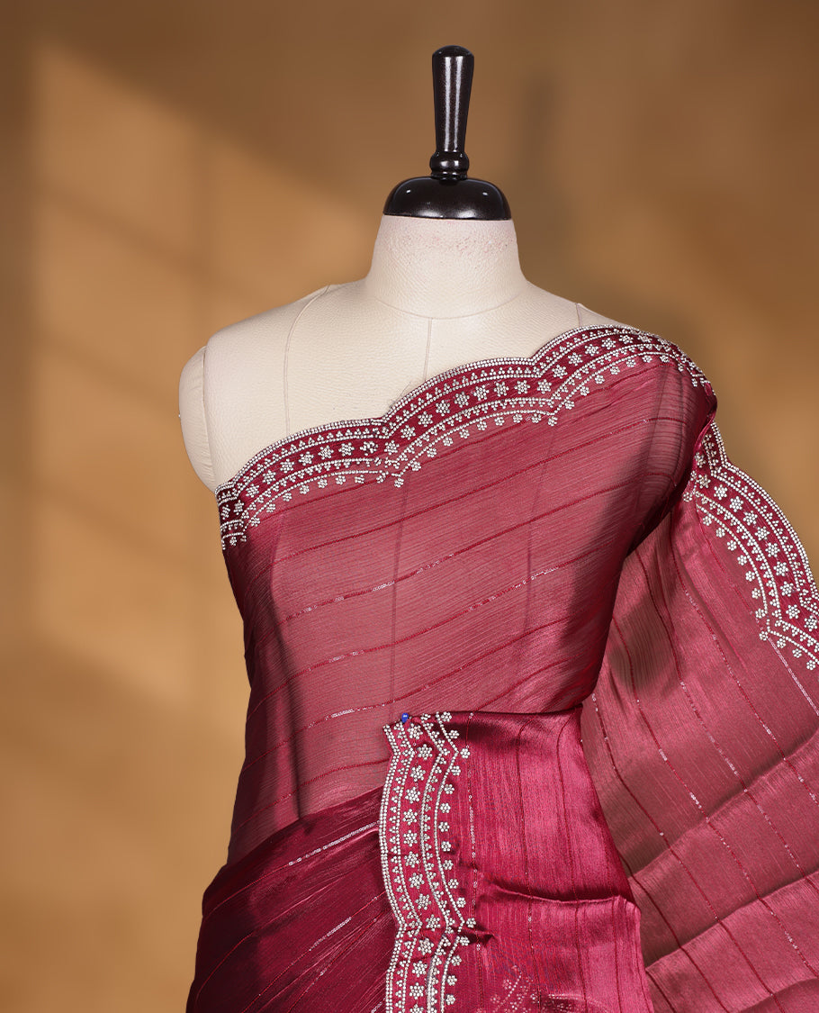 Burgundy colour chiffon designer saree, featuring self colour beats stripes on body, heavy gold stone patttern on border and pallu, Paired with matching blouse.