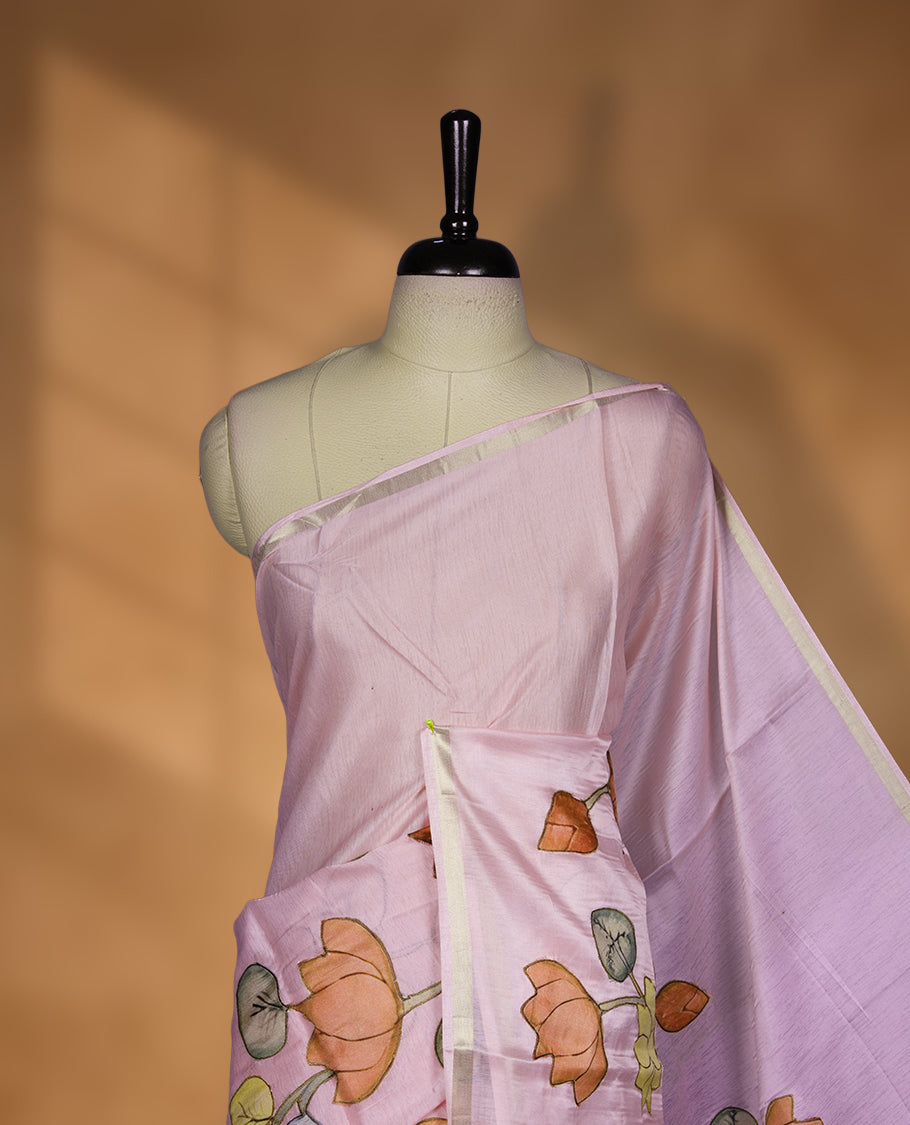 Pastel Pink colour semi tusser silk saree featuring delicate hand painted floral motifs along the pallu and border finished with subtle tassels and paired with a matching blouse.
