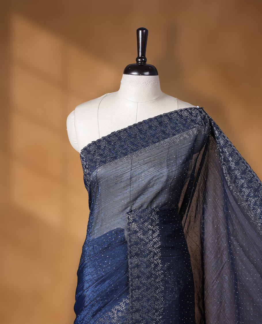Dark blue colour chiffon designer saree, featuring white stone all over on body, heavy stone patttern on border and pallu, Paired with matching blouse.
