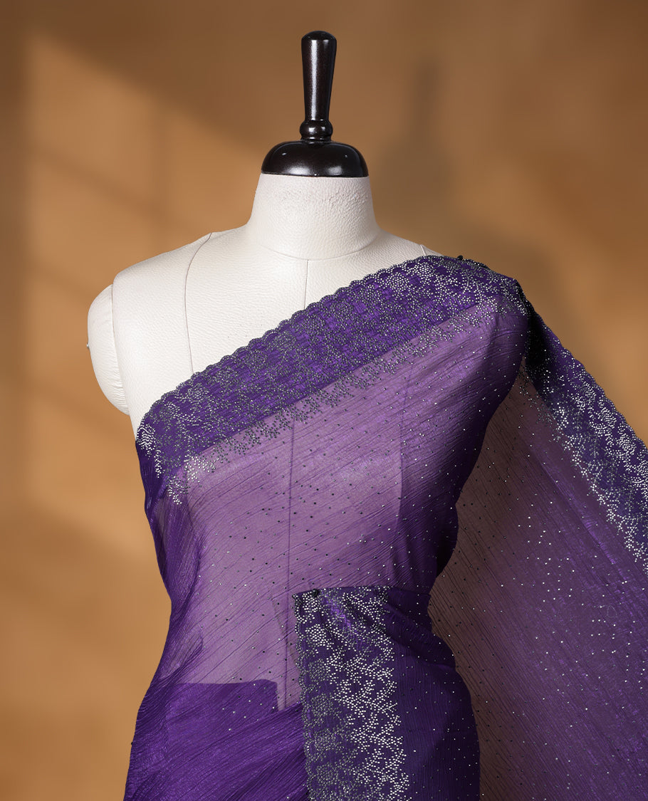 Violet colour chiffon designer saree, featuring white stone all over on body, heavy stone patttern on border and pallu, Paired with matching blouse.