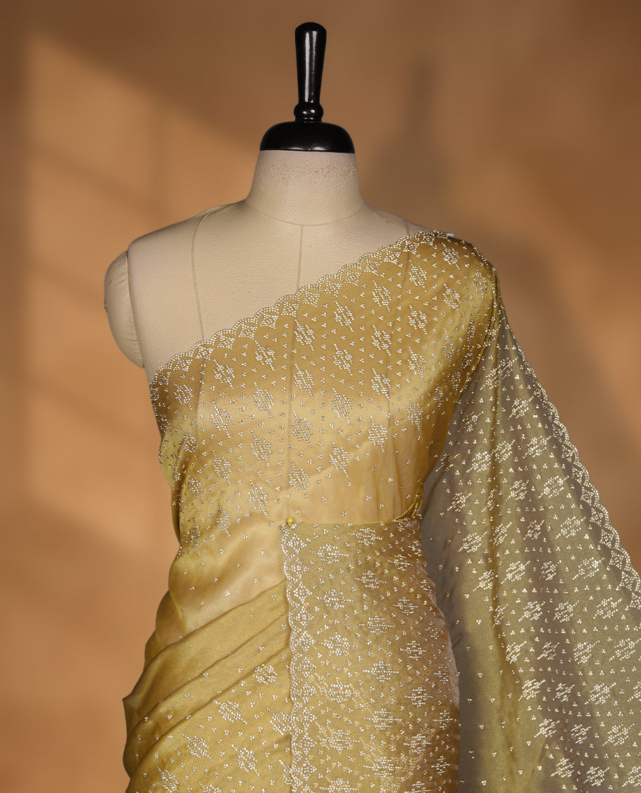 Gold Colour Shimmer Designer Saree featuring Delicate gold Stone Scattered Work on the Body, enhanced with Intricate Stone Detailing on the Border and Pallu, paired with a Matching Blouse.