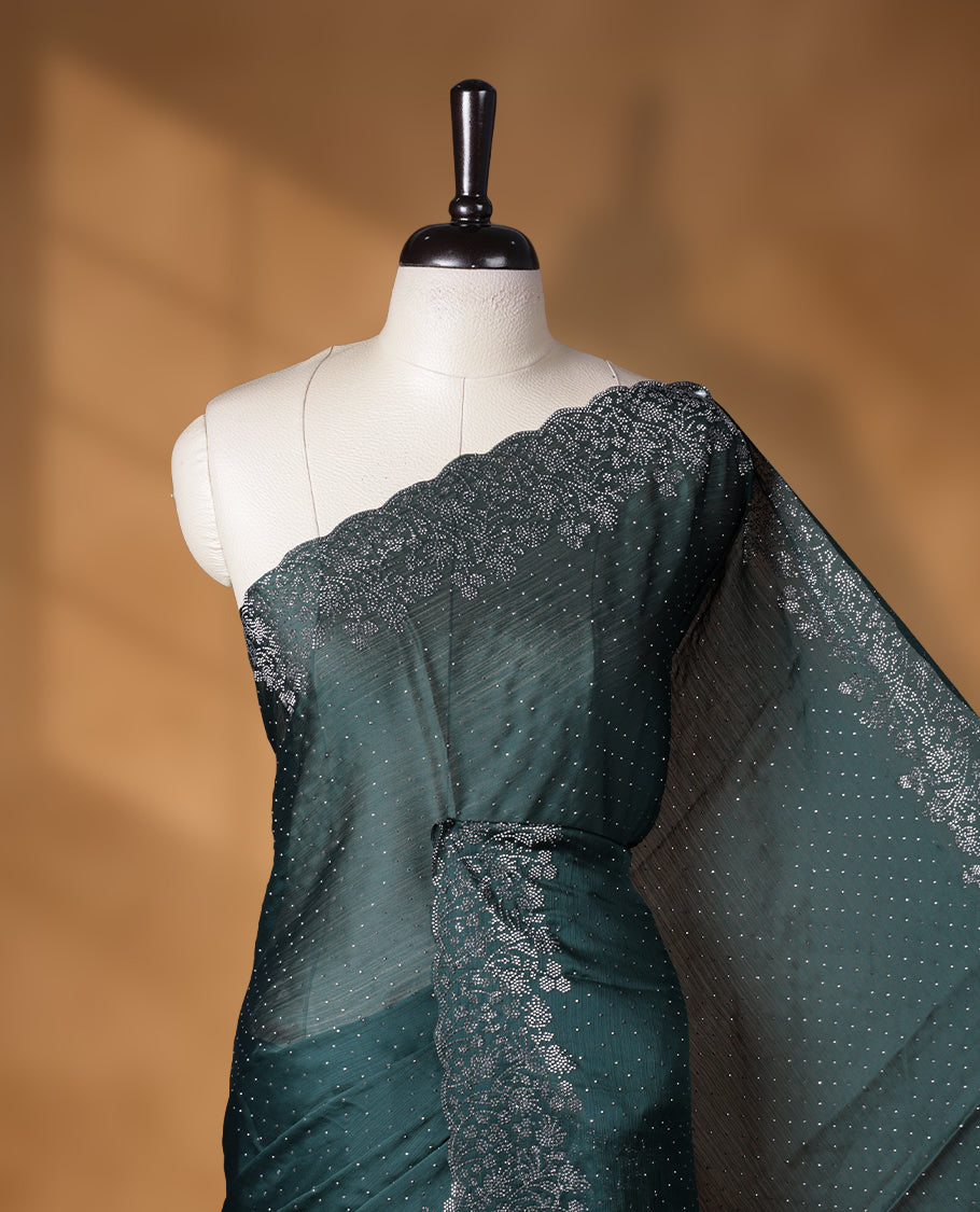 Dark green colour shimmer designer saree, featuring white scattered stone on body, stone work and heavy stone floral pattern on border and pallu, Paired with matching blouse.
