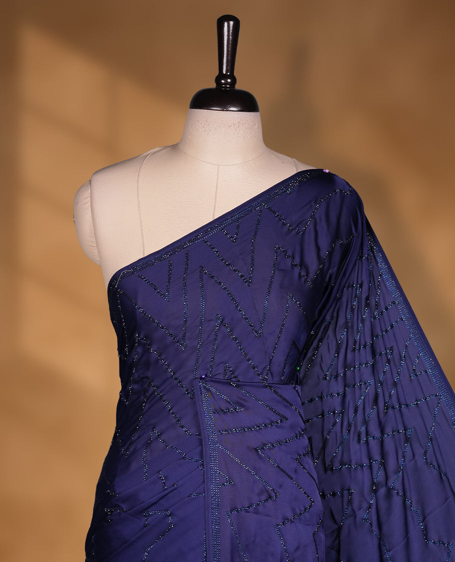 Dark blue colour chiffon fancy saree featuring white Self colour beats stripped pattern on body and detailing on the border and paired matching blouse.