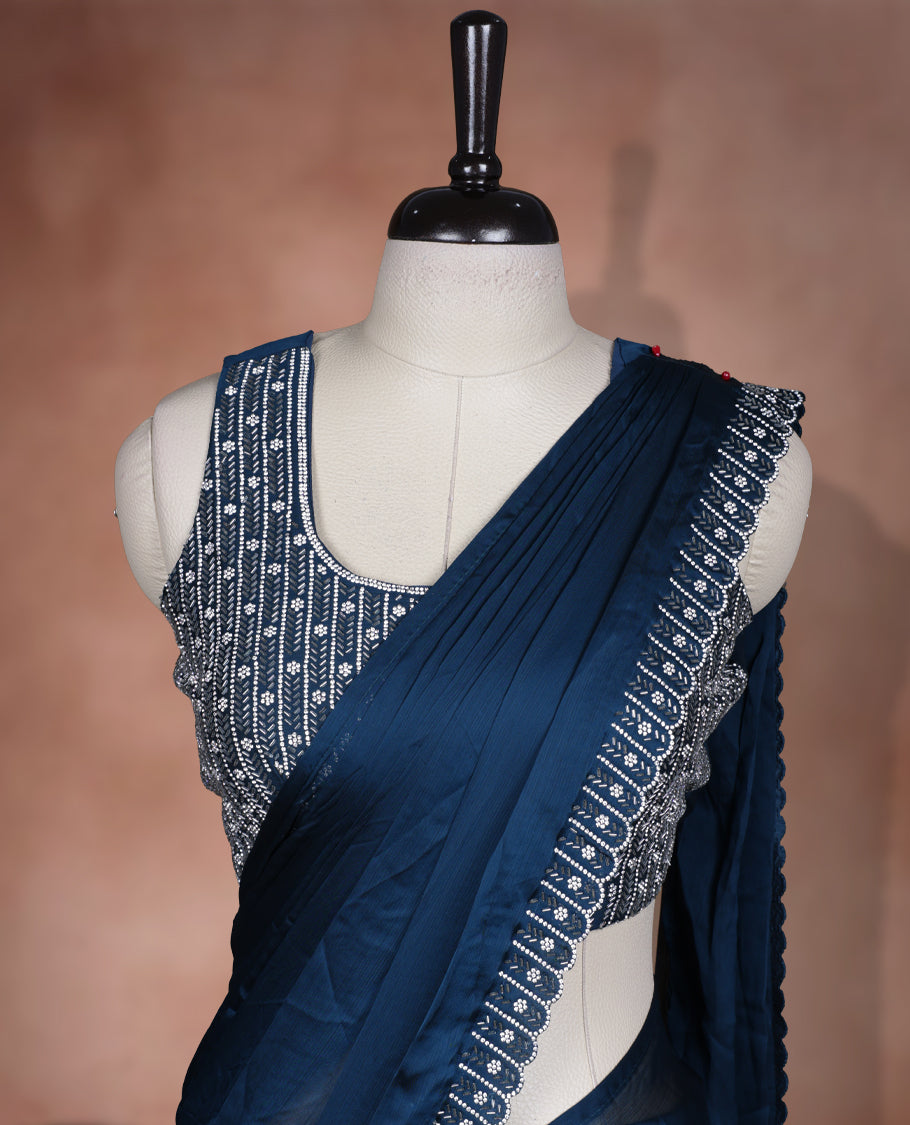 Elegant Teal colour ready to wear saree adorned with rich silver Stone and bead embroidery along the border and pallu, paired with a heavily embellished matching blouse for a grand festive look.