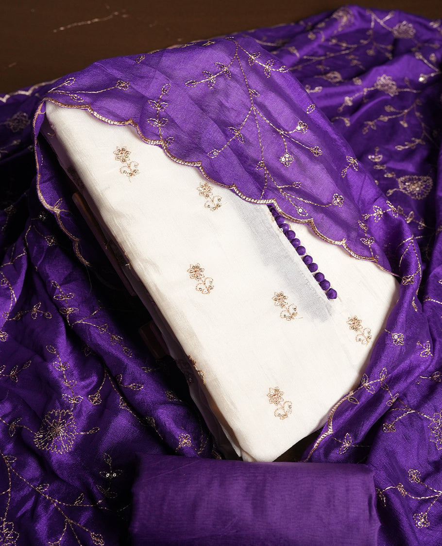 White colour churidhar material featuring thread embroidery on the front panel, contrast Violet colour dupatta with elegant border, and matching plain bottom