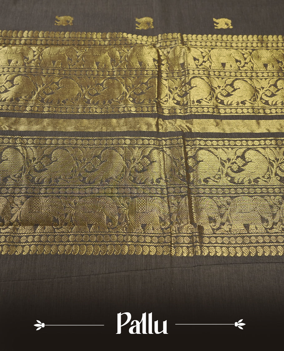 Grey colour Pure Kanchi cotton saree adorned with subtle golden buttas all over, highlighted by a rich zari woven border with traditional motifs & Includes a matching blouse piece for a complete look.