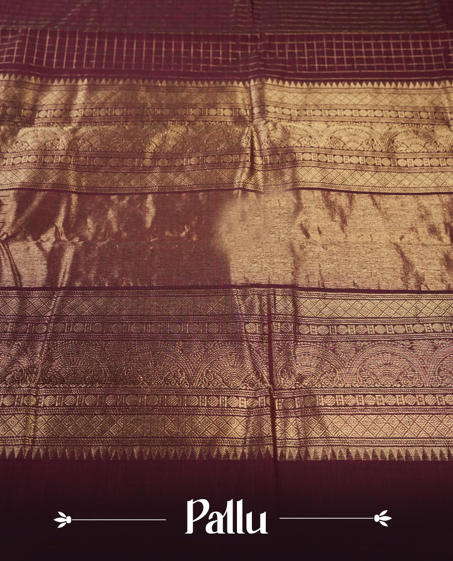Maroon colour pure Kanchi cotton saree featuring with delicate golden checks on body, paired with a contrasting navy blue zari woven border & Includes a matching blouse piece for a complete look.
