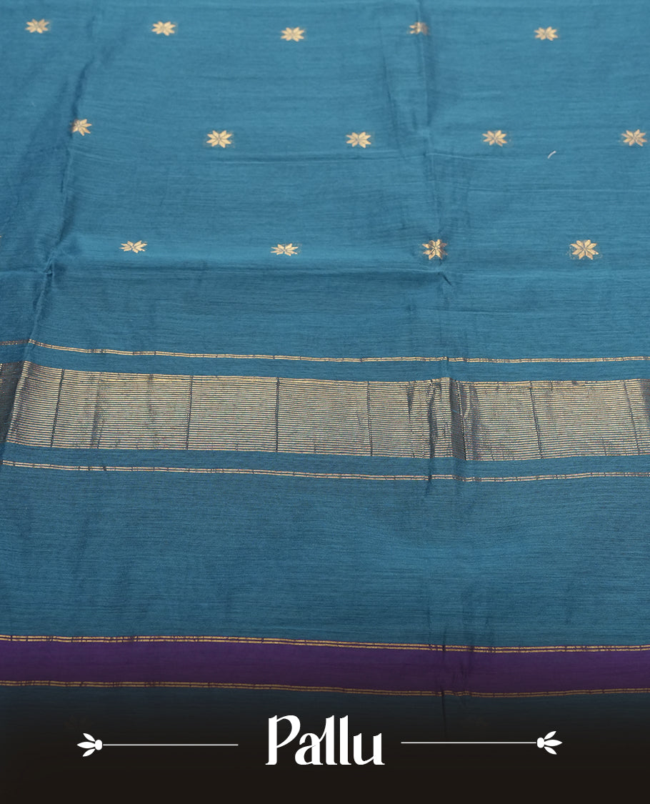 Teal Blue Colour silk cotton saree featuring small zari buttas on the body, contrast purple section, zari pallu, and matching blouse with border detailing.