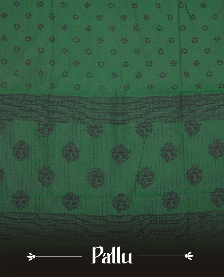 Green colour poly cotton saree with black floral butti motifs on the body, paired with a matching pallu featuring black ornate floral jaal and stripes on the border, and a coordinated all‑over black paisley printed blouse piece.