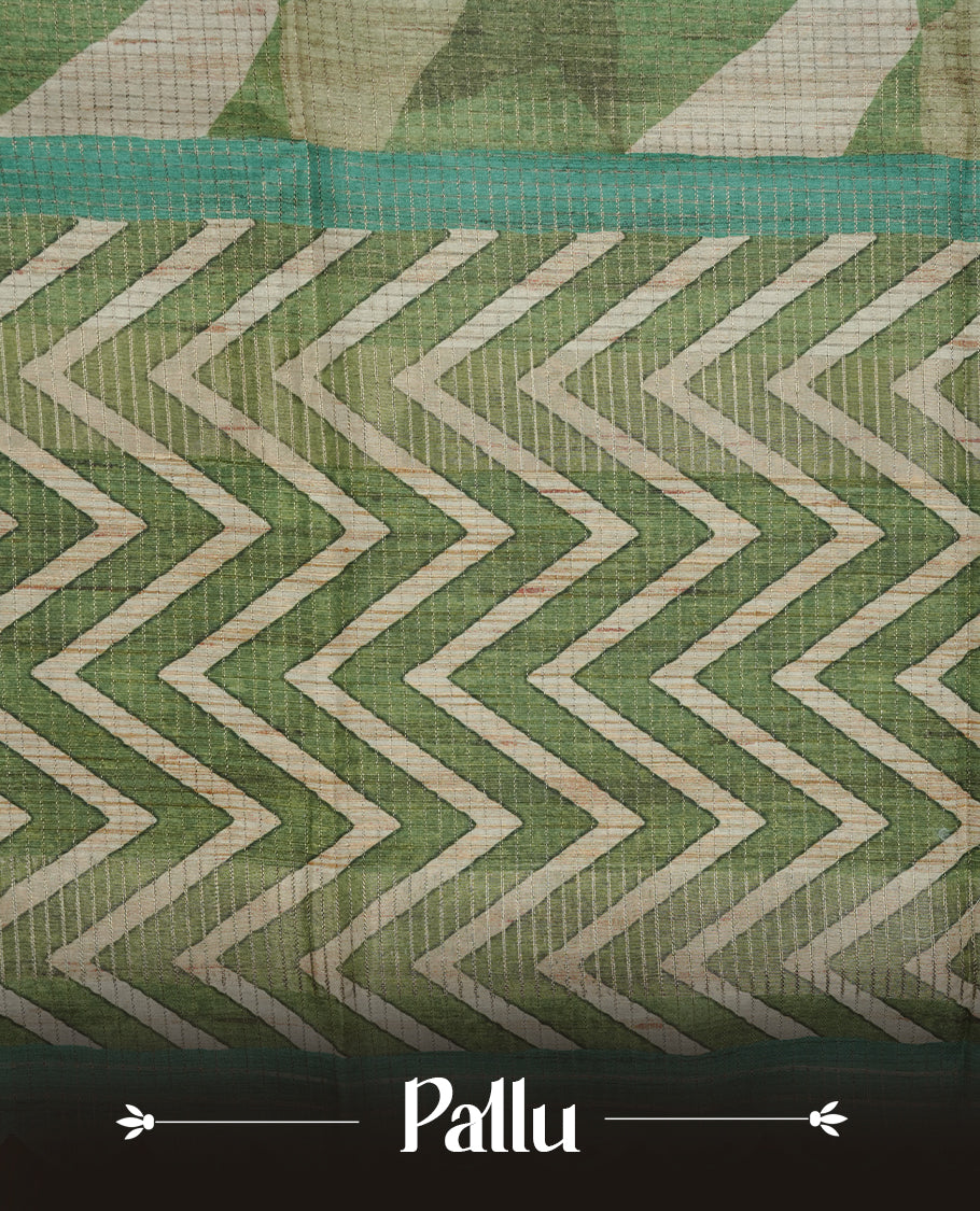 Green colour semi tussar silk saree featuring zigzag print and zari check pattern across body, self colour border with geometric pattern and pallu, paired with matching blouse piece.