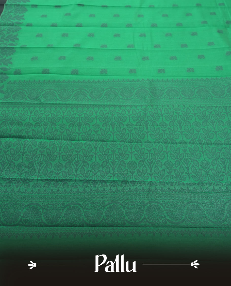 Emerald green colour silk cotton saree featuring subtle woven motifs throughout the body, enhanced by a striking grey contrast border and an intricately designed pallu with floral patterns & Comes with a matching blouse piece.