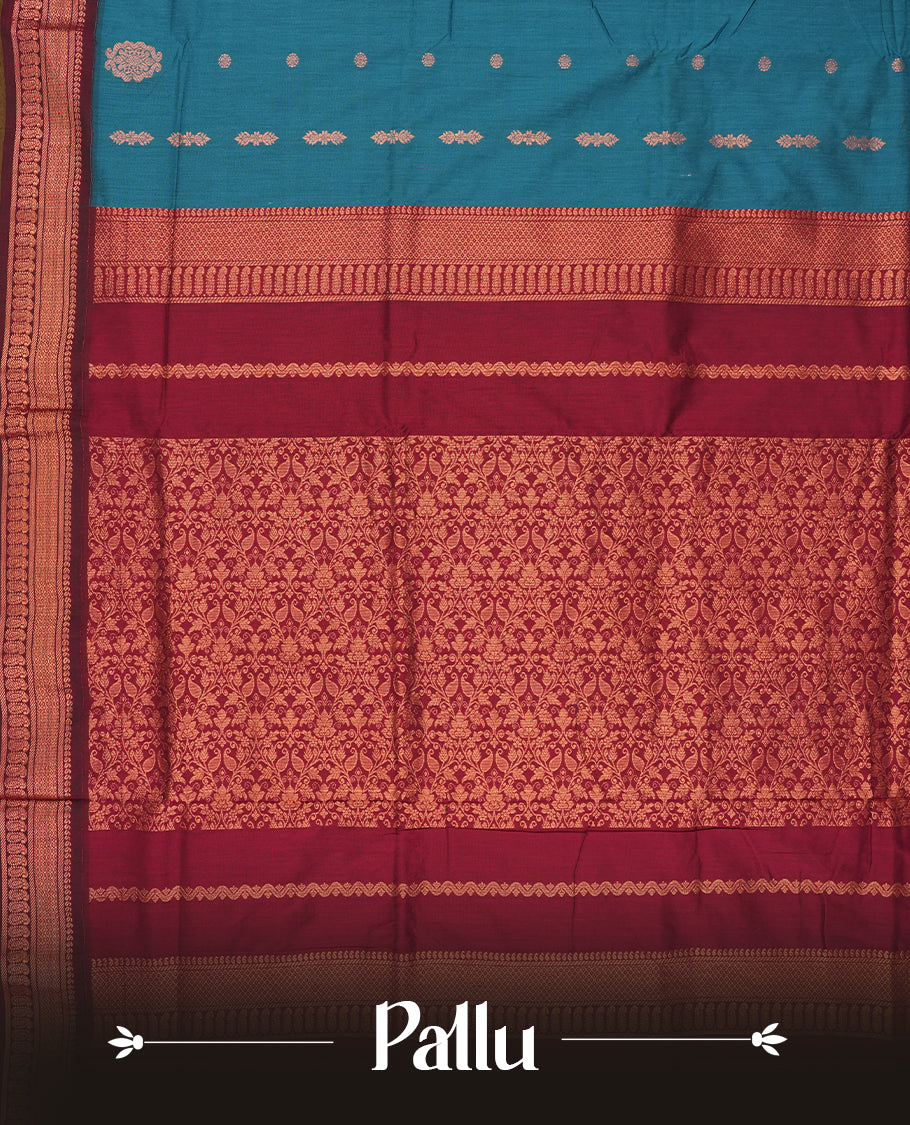 Blue colour Kalyani Cotton saree in deep maroon with golden floral motifs, paired with a contrasting maroon border featuring intricate zari work & Comes with a matching blouse piece.