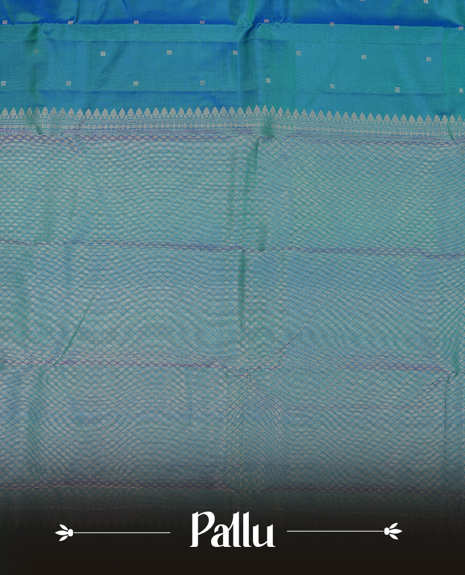 Teal colour Vasundhara silk saree adorned with all-over silver square motifs on the body, complemented by a green & blue box pattern border and paired with a matching blouse piece.