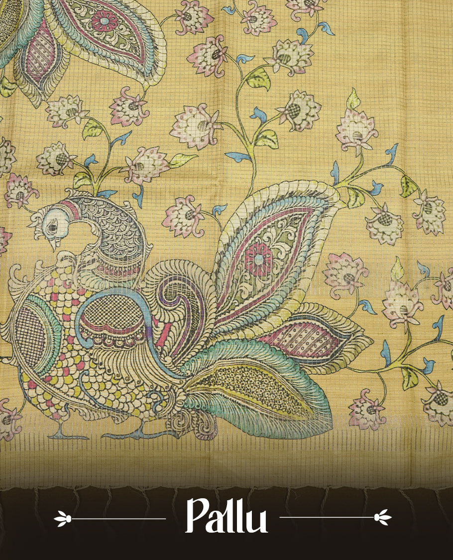 Mustard yellow colour semi tussar silk saree with Kalamkari-inspired peacock pallu, floral printed body, subtle textured weave, and tassel finish, paired with a matching printed blouse piece.