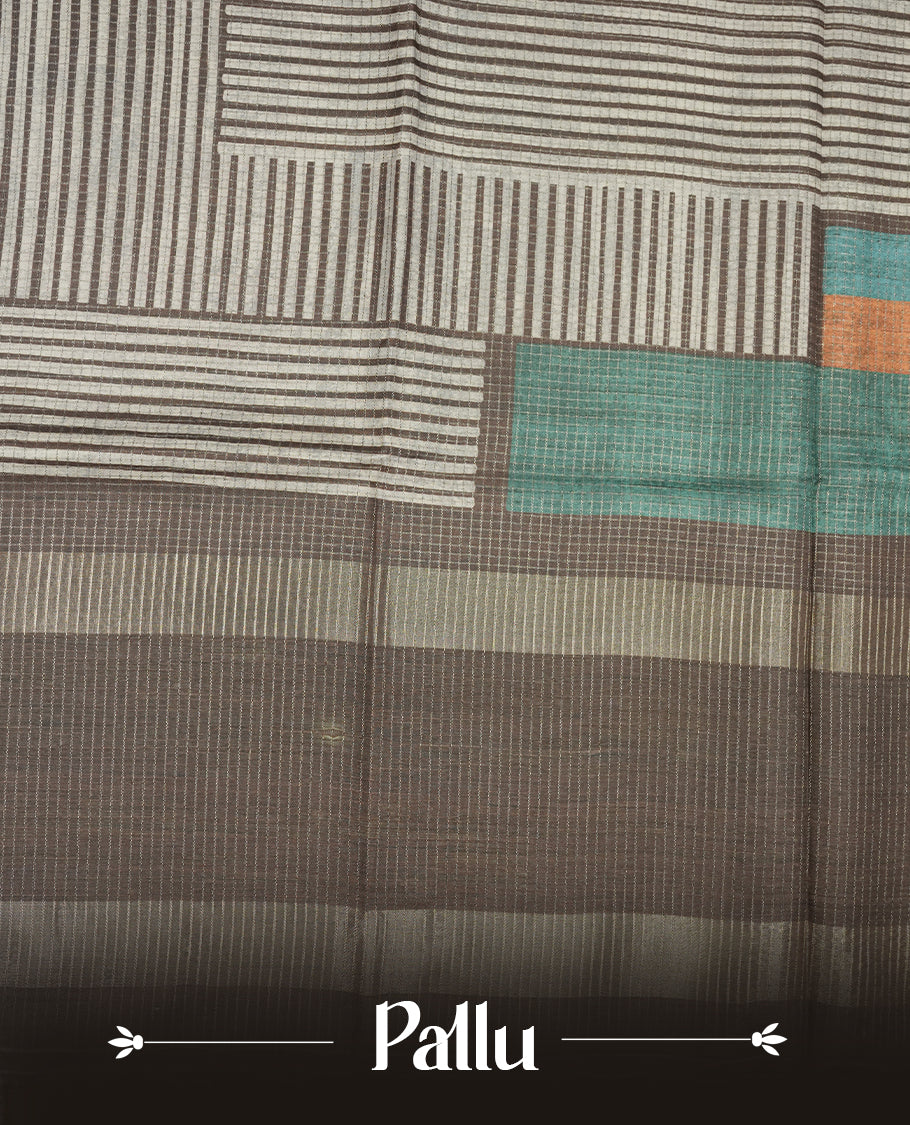 Charcoal Brown colour semi tussar silk saree crafted in breathable cotton, featuring subtle striped textures across the body, a minimalist pallu with fine linear detailing, and a coordinated plain blouse piece.