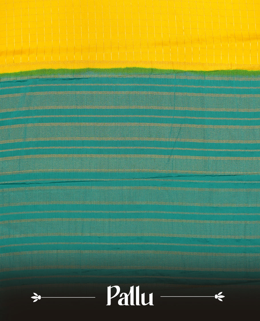 Yellow colour mysore crepe saree with gold zari check pattern on body, complemented by contrast Green colour border featuring peacock and chakkram motifs, paired with matching blouse.