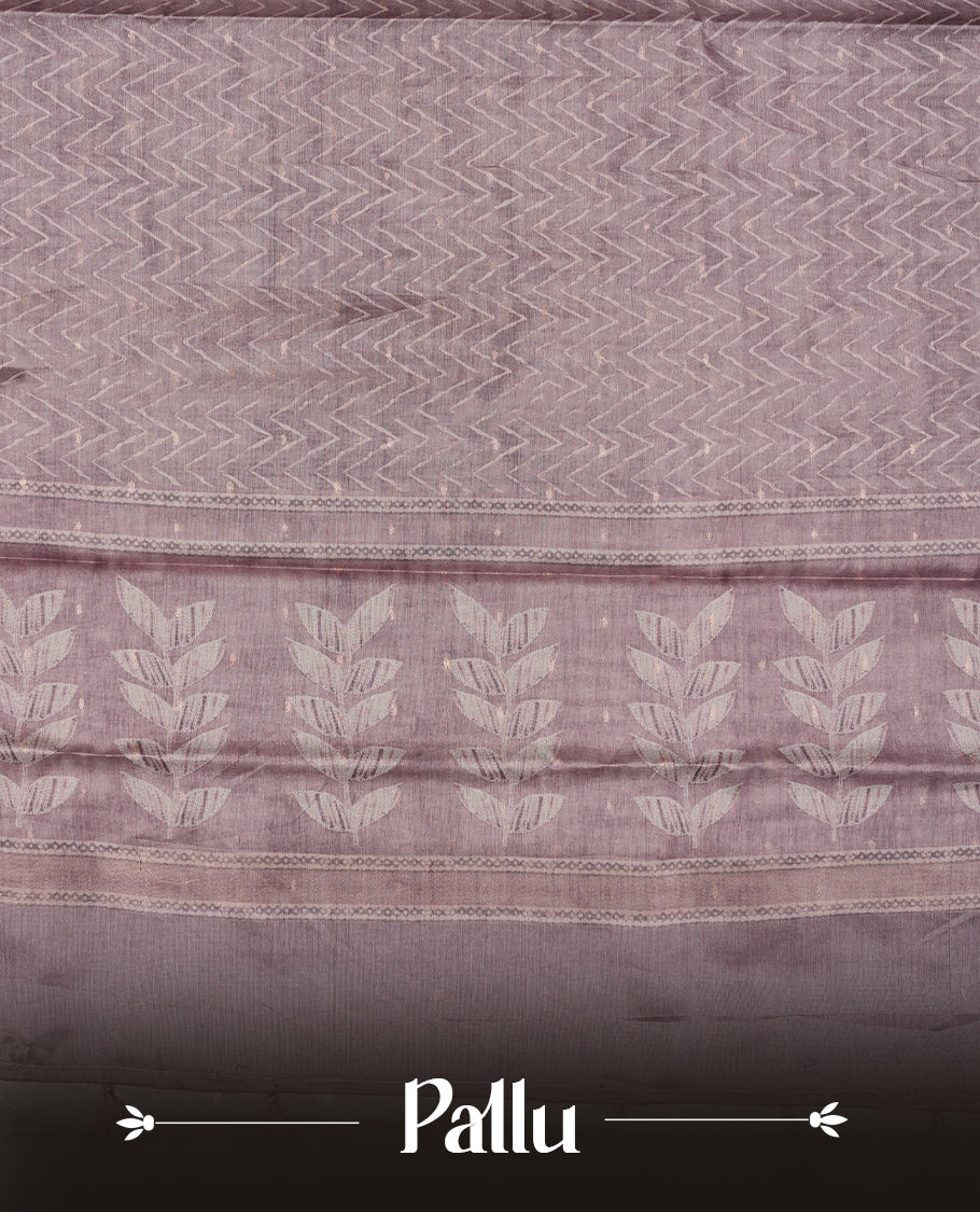 Pink copper colour semi tussar saree adorned with Cream Zigzag printed pattern across the body and Leaf pattern on contrast Dusty pink colour border, paired with a matching blouse.