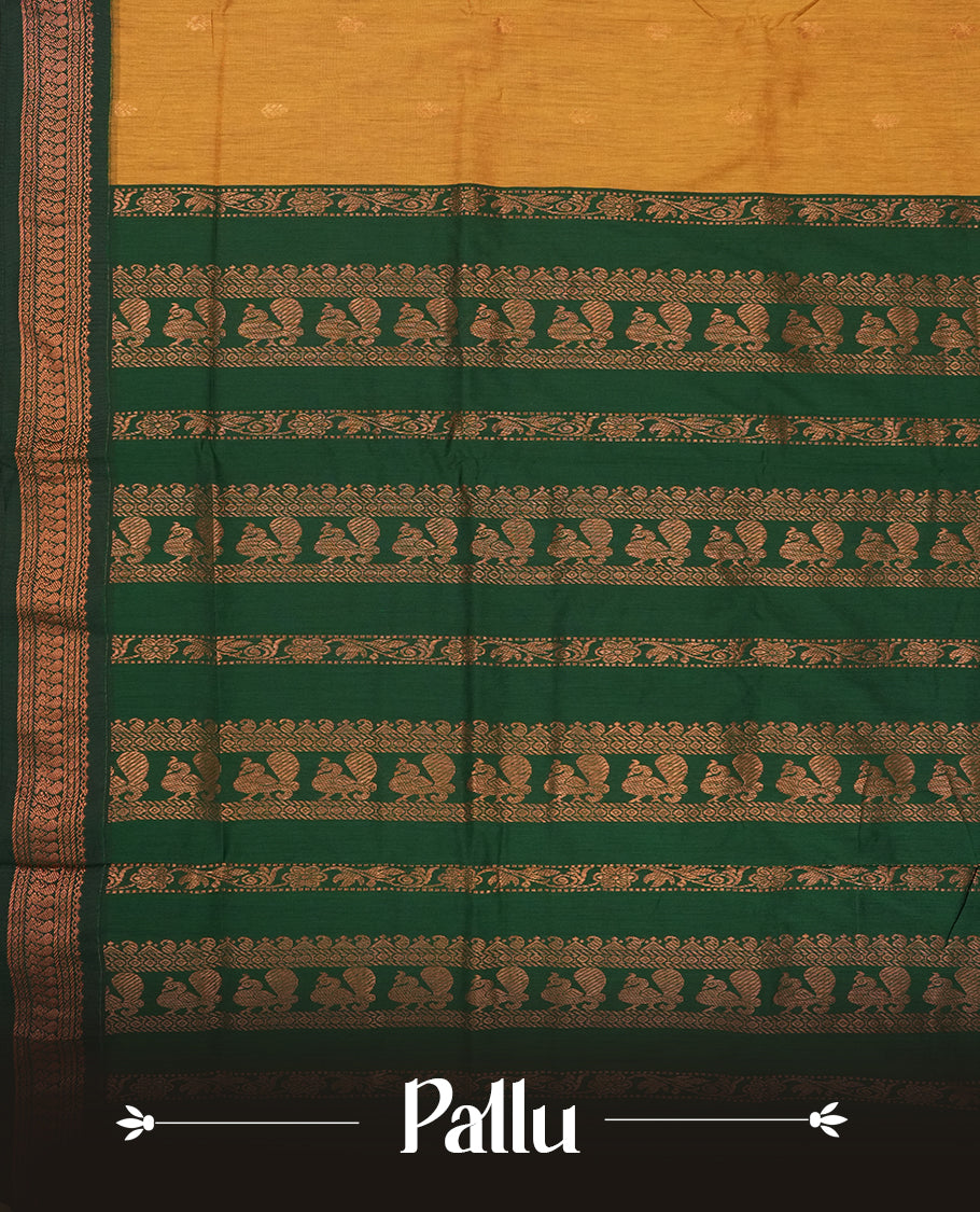 Mustard yellow colour Kalyani Cotton saree with golden motifs, paired with a contrasting green border featuring intricate peacock zari work & Comes with a matching blouse piece.