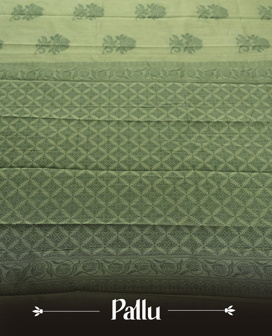 Pastel green colour silk cotton saree featuring elegant floral zari motifs on the body, complemented by a rich contrast dark green border and pallu with traditional woven detailing & Comes with a matching blouse piece.