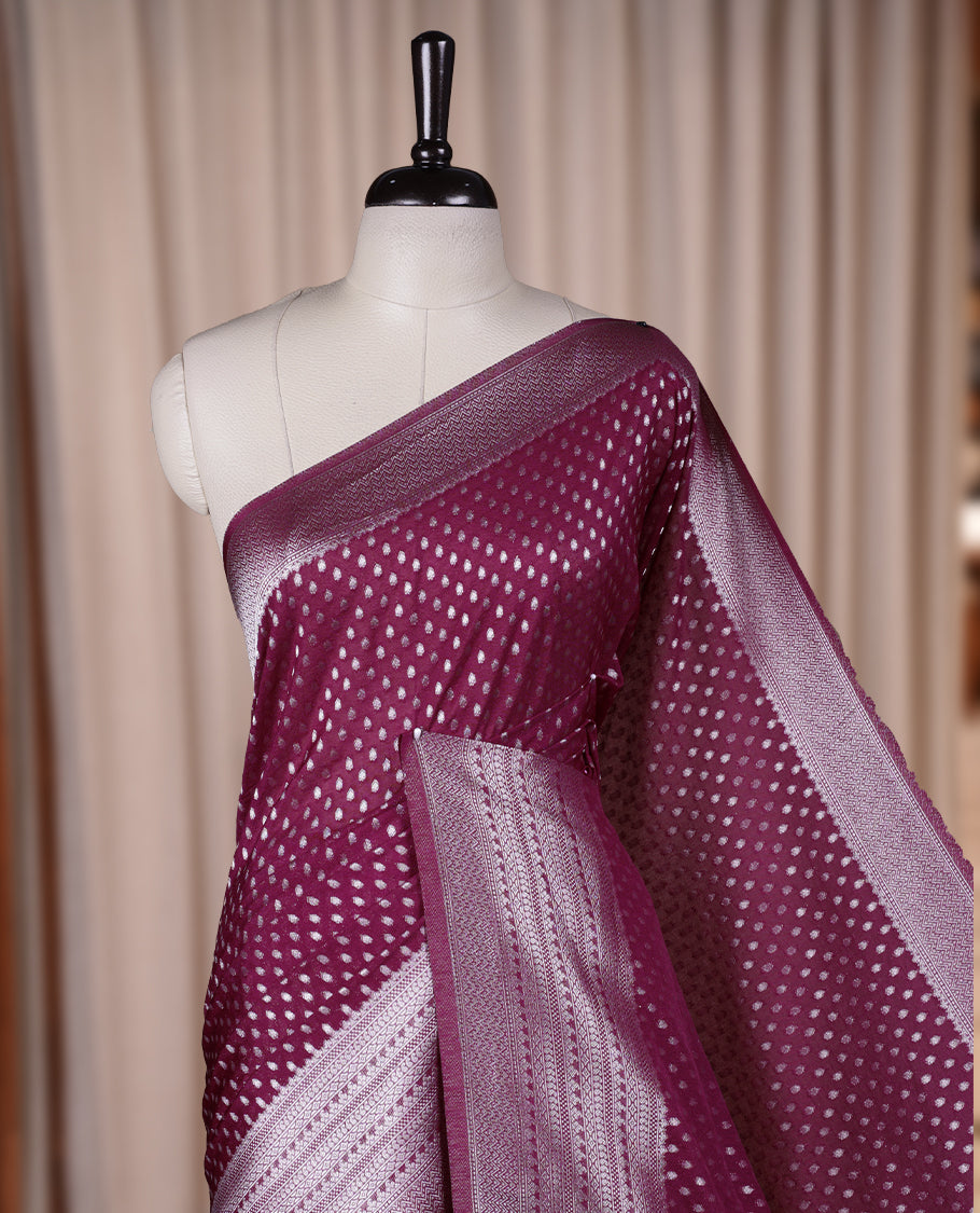 Wine colour Banarasi silk saree featuring intricate zari weaving and a soft silk texture, Adorned with silver motifs on the body, complemented by a rich Banarasi border and pallu & Comes with a matching blouse.